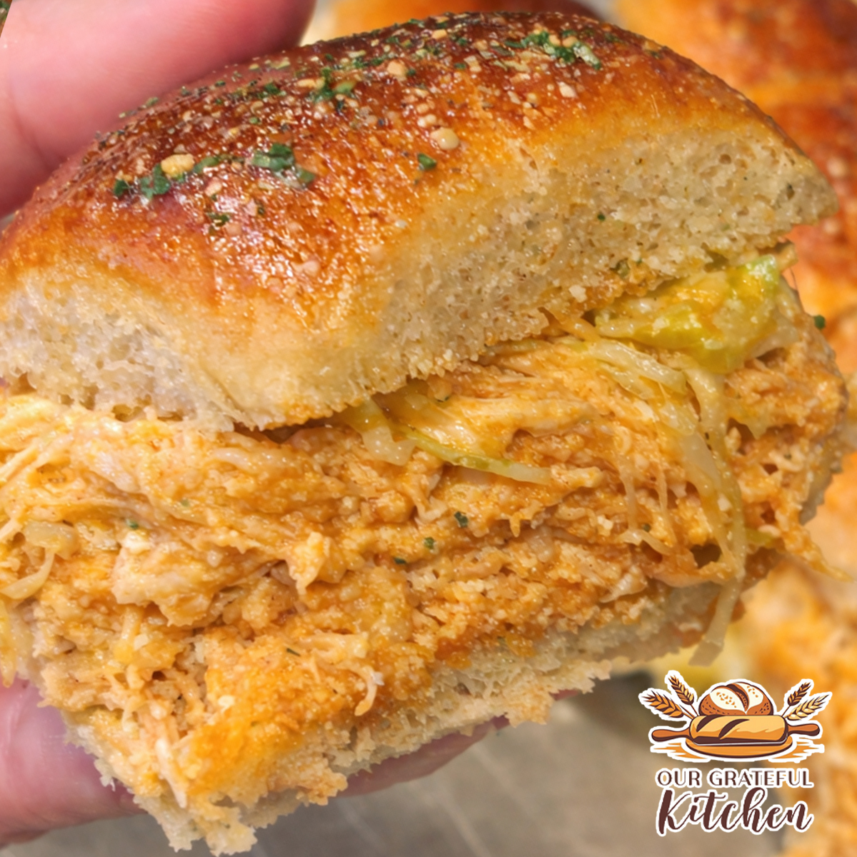 Close up buffalo ranch chicken sliders on Hawaiian rolls with shredded chicken, melted cheese, and ranch sauce