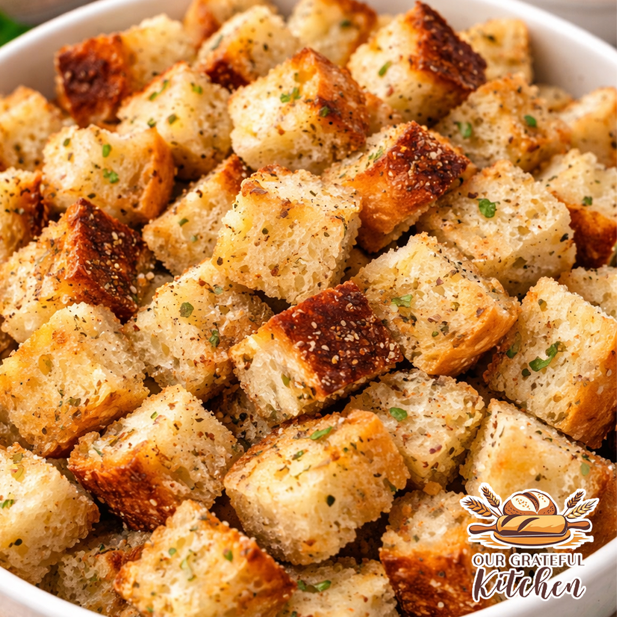golden crispy homemade croutons in a bowl seasoned with Italian herbs and garlic showing airy bread texture and crunchy edges