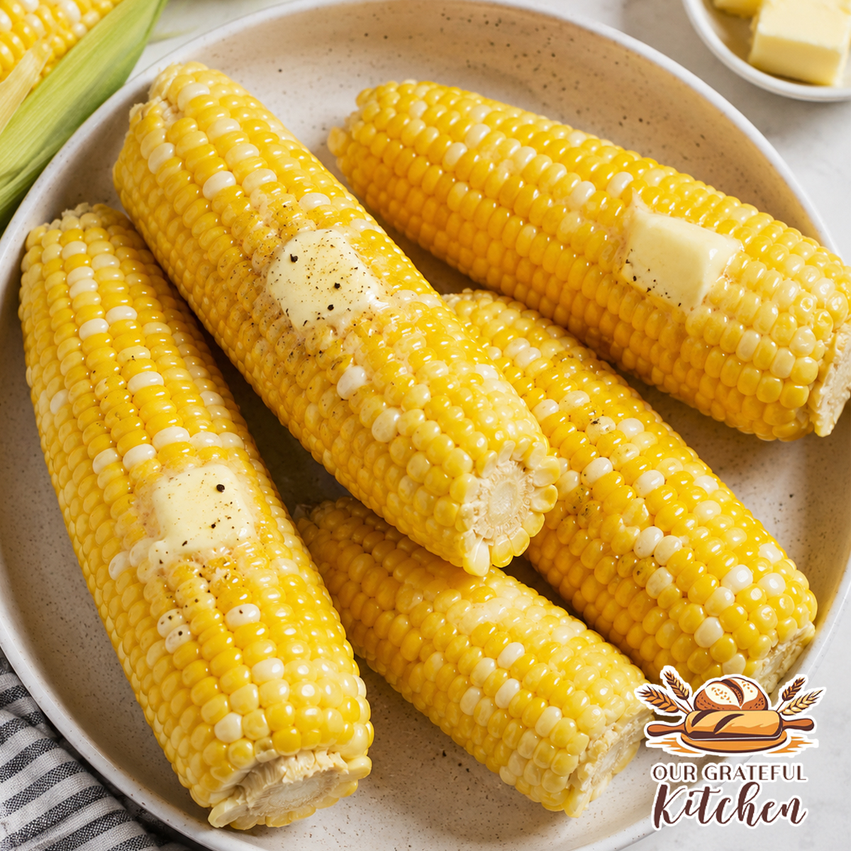 Fresh boiled corn on the cob with melted butter and black pepper served in a bowl.