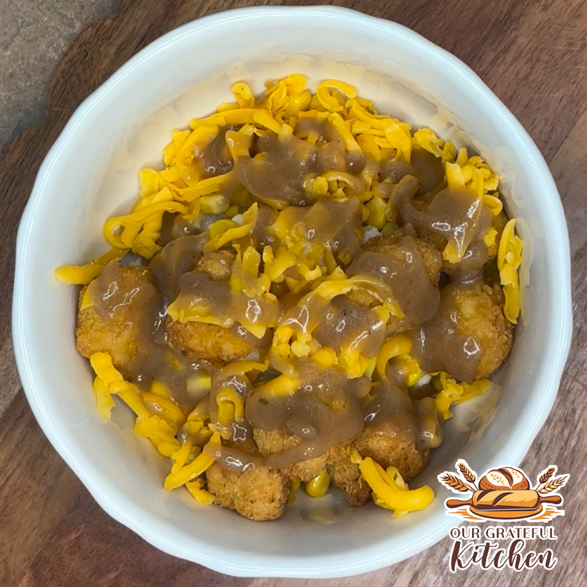 Homemade KFC Famous Bowl copycat topped with crispy popcorn chicken, buttery corn, rich brown gravy, and melted cheddar cheese over creamy mashed potatoes.