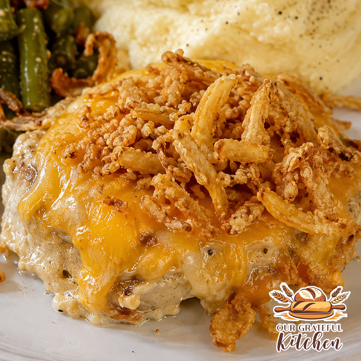 Crockpot French onion smothered pork chops topped with melted cheddar and crispy French fried onions