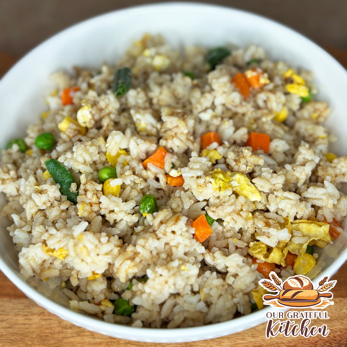 Easy egg fried rice with peas, carrots, corn, and scrambled eggs cooked until lightly toasted.