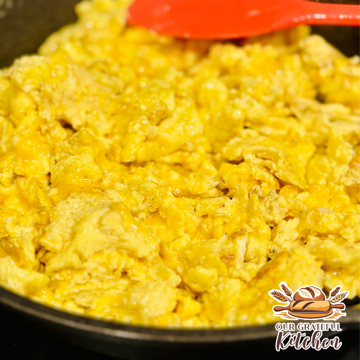 Fluffy cheesy scrambled eggs with melted cheddar cheese