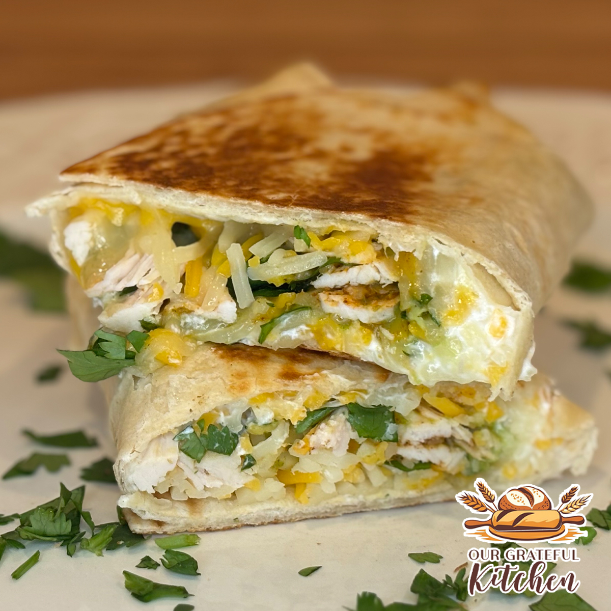 Grilled chicken and avocado burritos filled with shredded chicken, cheese, avocado, and cilantro