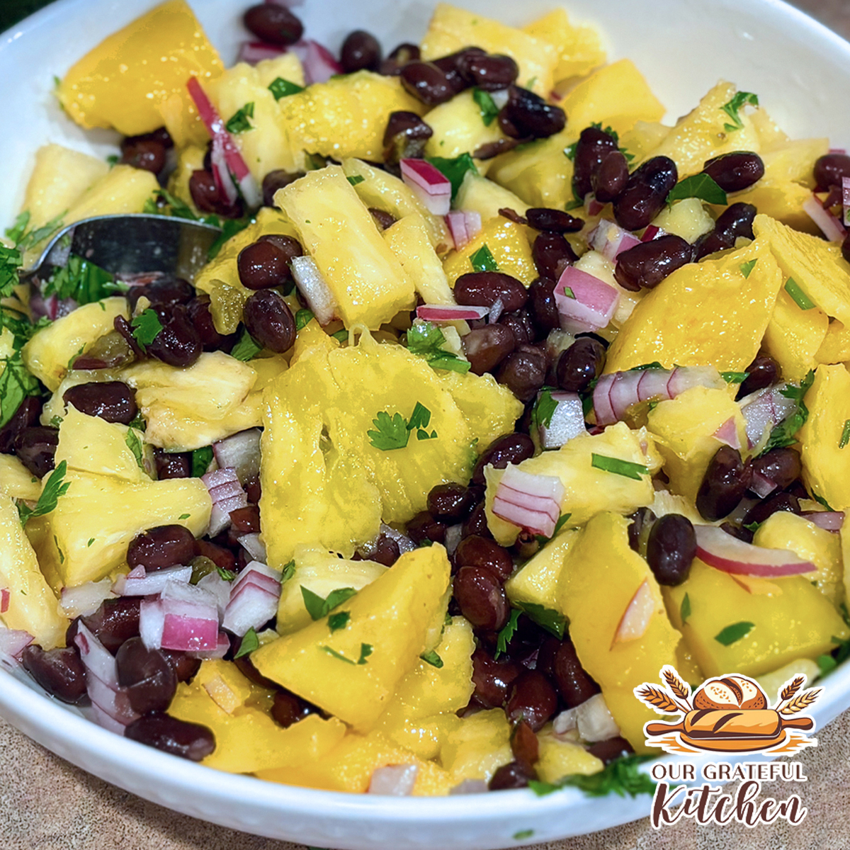 Pineapple mango salsa with black beans mixed together in a bowl